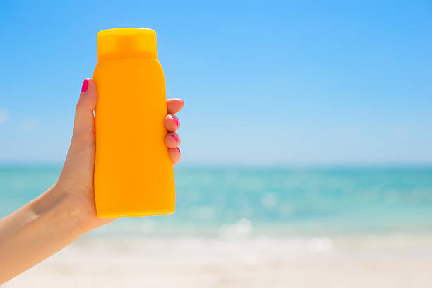 istock Woman holding sunscreen bottle 472381732