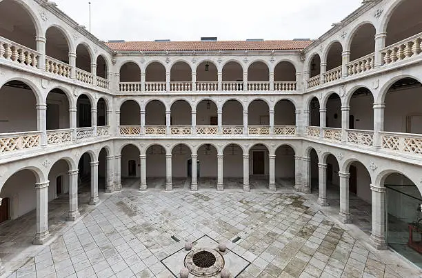 Wide-angle view of the four sided cloister and inner colonnades of the Colegio de Santa Cruz, the first building of the University of Valladolid. Founded by Cardinal Mendoza and built at the end of the 15th century, this public building now hosts the rectorate of the University and the old library.