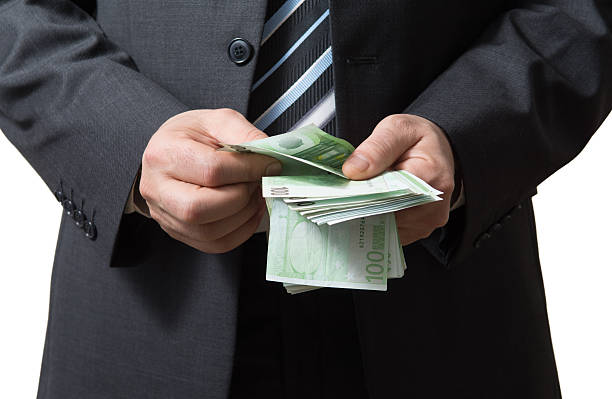 istock Businessman counts money 472386340