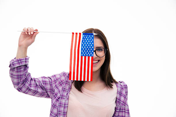istock Smiling young girl covering her eye with flag 472386372