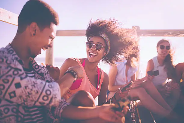 Photo of Afro girl in sunglasses laughing out loud with friends