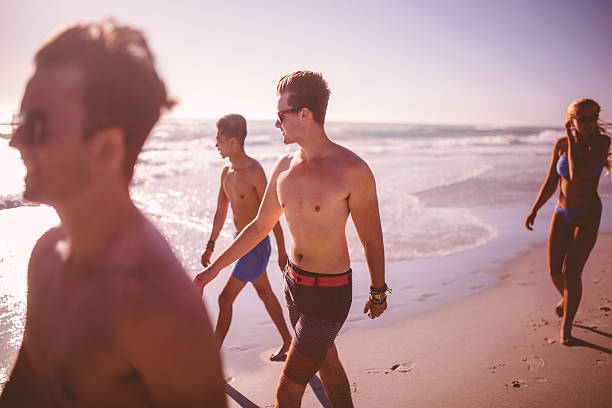 istock Guy friends walking along the beach on a summer day 472391944