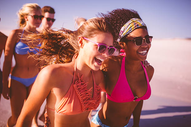 istock Afro girl walking with her friend on a beach 472391948