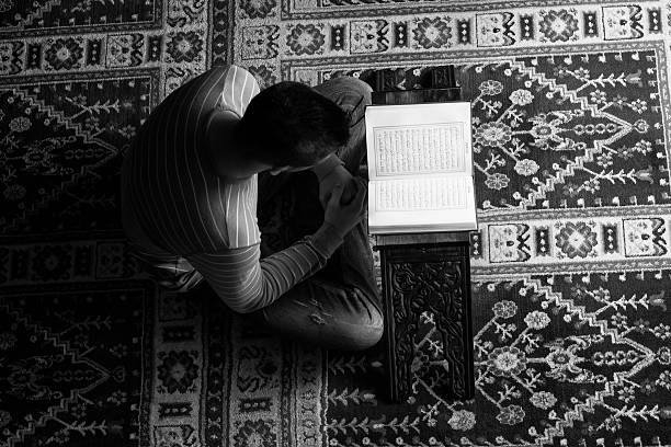 istock Arabic Muslim Man Reading Holy Islamic Book Koran 472393482