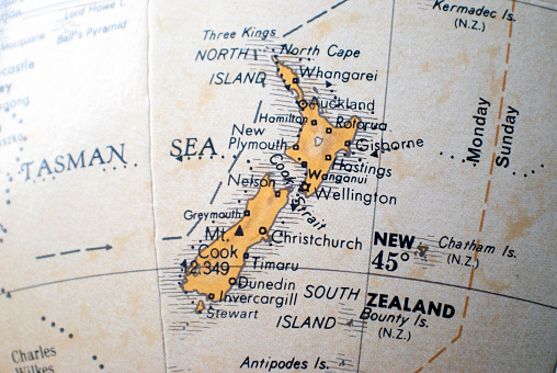 close up of a map of New Zealand on a world atlas, showing the North and South Islands