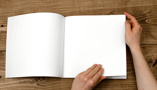 istock Reading a blank brochure on a wooden background 472398020