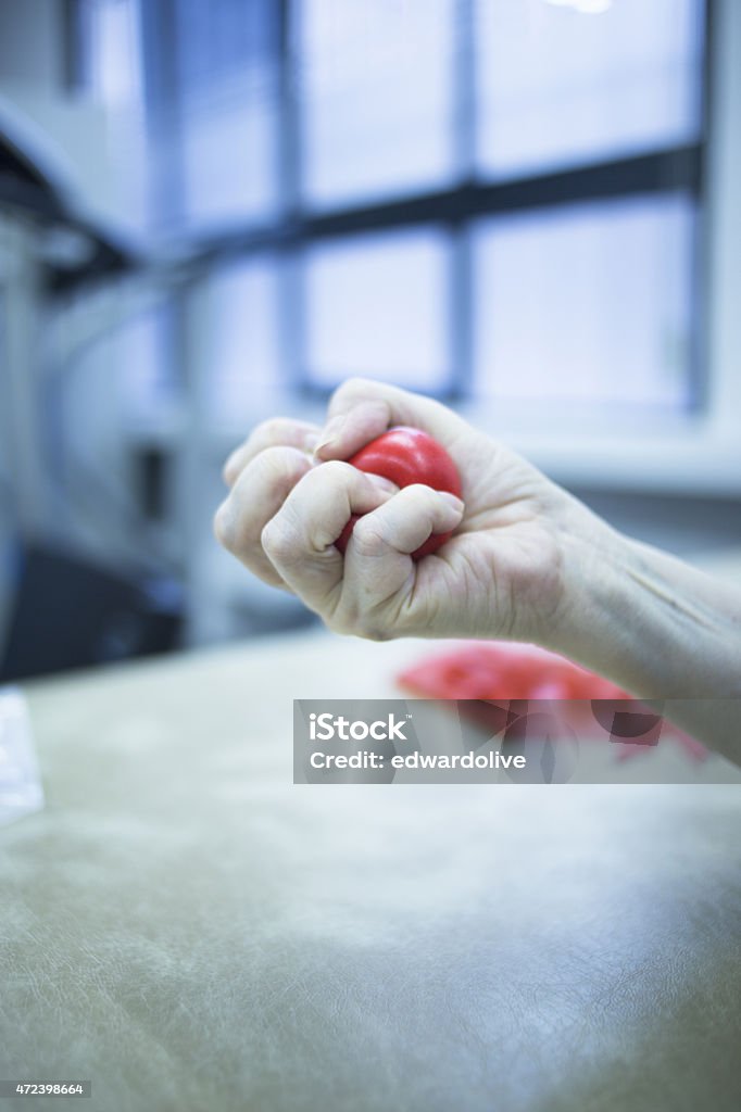 Hand muscle injury strain pain physiotherapy treatment Hand stimulation used to treat pain, muscles injuries, strains and tension in hospital physiotherapy medical rehabilitation clinic for patient using rubber ball exercises. 2015 Stock Photo