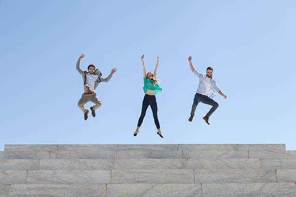 istock Three friends jump on top of a staircase 472405474
