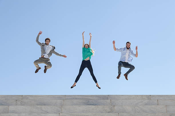 istock Three friends jump on top of a staircase 472405484