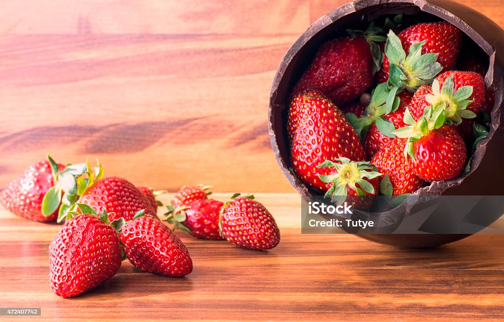 Chocolate Easter egg filled with strawberries Chocolate Easter egg with the top broken off filled with strawberries 2015 Stock Photo