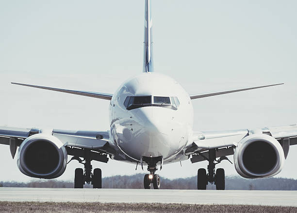 Taxiing Passenger Jet A passenger jet taxis towards an airport gate after landing. airport runway photos stock pictures, royalty-free photos & images