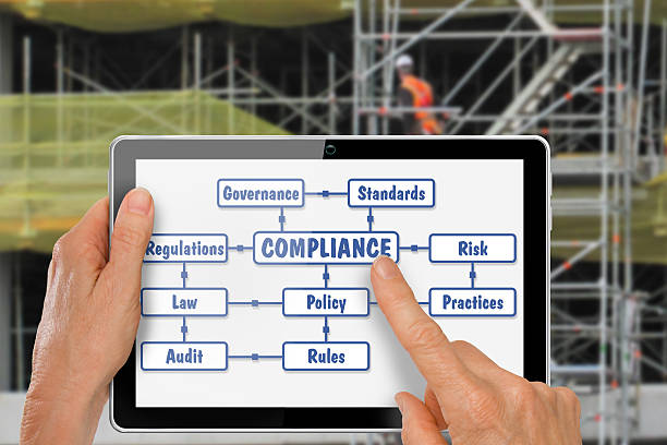 Tablet with Hands Researching Compliance Construction stock photo