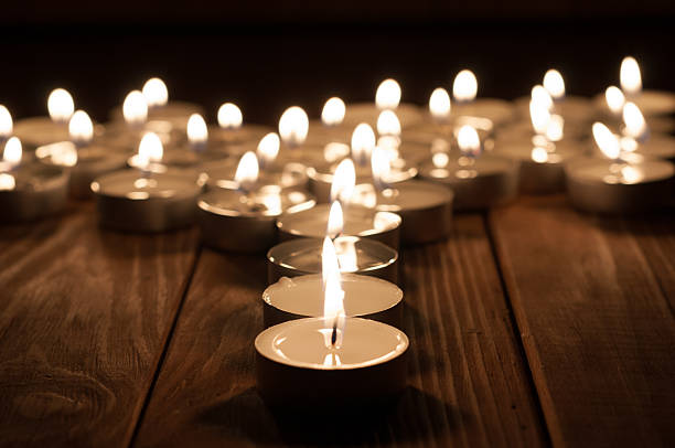 istock Candle and blurry candles on old wooden background 472465660