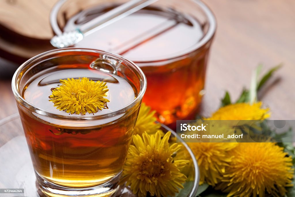 dandelion tisane tea with yellow blossom inside teacup dandelion tisane tea with fresh yellow blossom inside tea cup, on wooden table 2015 Stock Photo