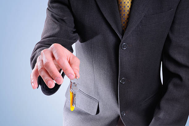 istock Half-body commercial agent with keys in hand isolated 472467302