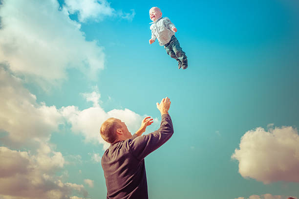 istock Father throwing son in air ready to catch him 472468608