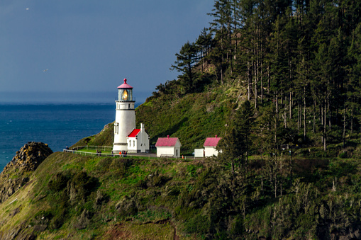 Historic Heceta Head lighthouse sitting on scenic headland cliffs along Oregonâs central coast on a stormy afternoon. A popular tourist attraction and landmark