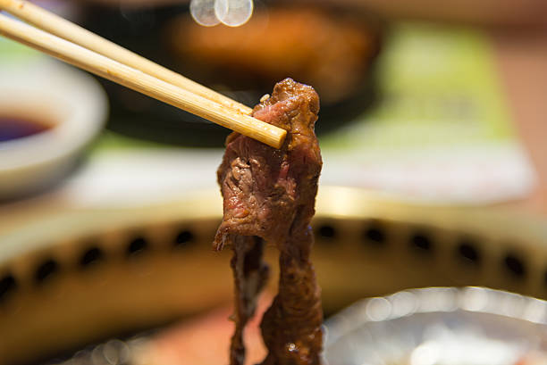 Grilled piece of beef with chopsticks closeup