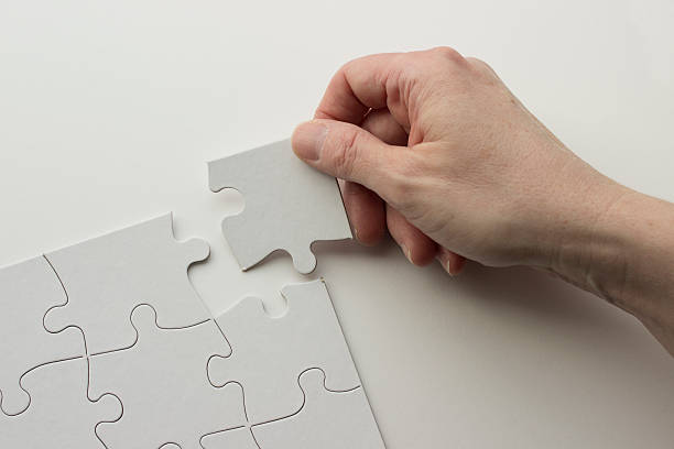 Hand Placing Puzzle Piece in Blank Puzzle