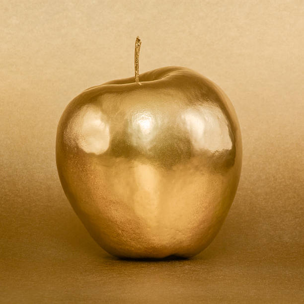 istock Whole golden apple on gold background 472469998