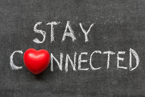 stay connected phrase handwritten on blackboard with heart symbol instead of O 