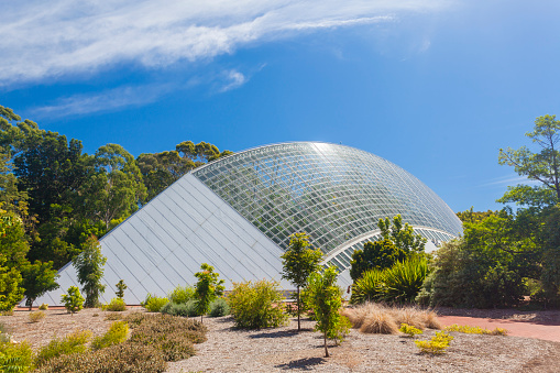 Giant modern greenhouse in a public botanic garden against blue sky