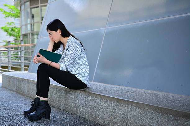 istock Long hair girl sat down to read book 472475562