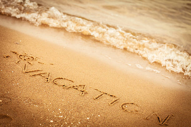 istock The word vacation written in the sand on a beach 472475664
