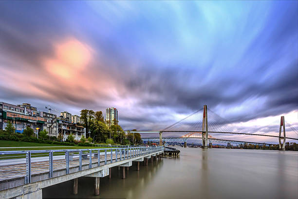 sunset glow over river and city sunset glow over river and city, with dramatic cloudscape new westminster stock pictures, royalty-free photos & images