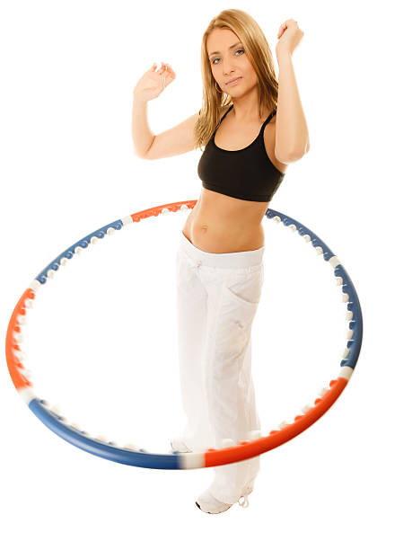 istock sporty fit girl doing exercise with hula hoop. 472477004