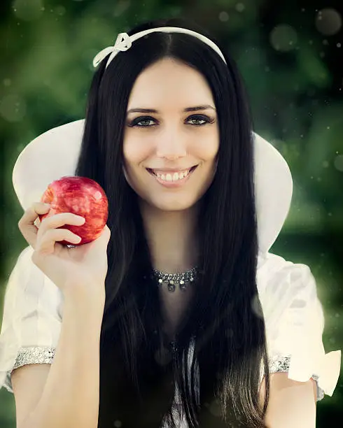 Snow White fairy tale character holding the apple in fantasy scene 