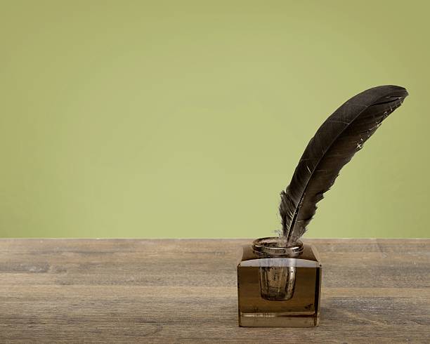 istock Write. Vintage background with quill pen and inkwell on table 472478548
