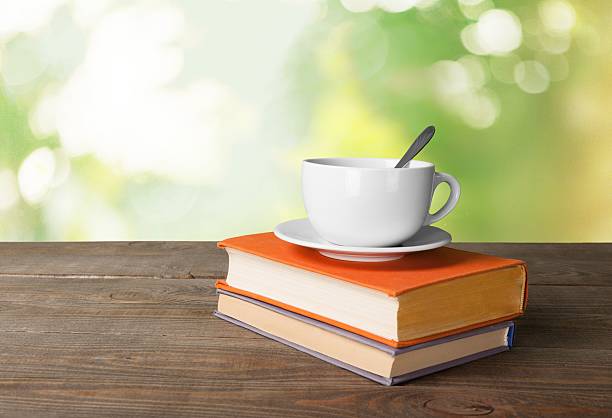 istock Tea. Cup of coffee and book on wooden table 472478720