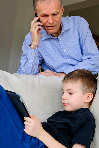 Modern father and son with electronics stock photo