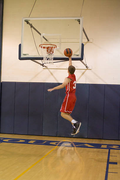 istock male high school basketball player going up for a layup 472484252