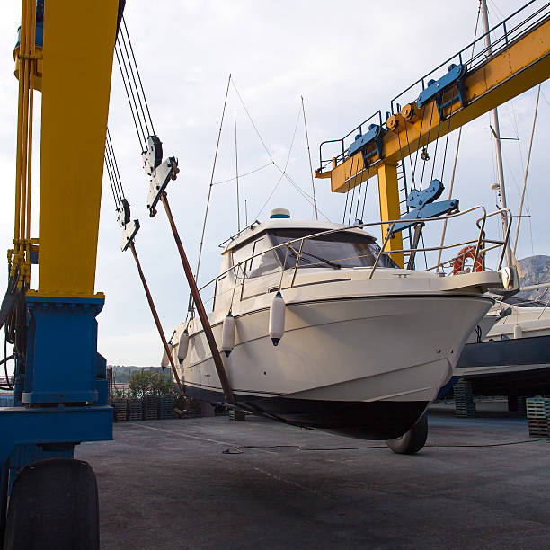 istock Boat wheel crane elevating motorboat to yearly paint 472484892