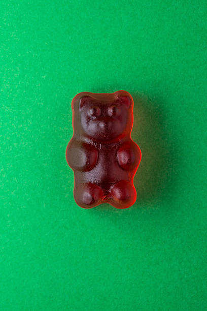 istock Red gummy bear candy on green paper 472485938