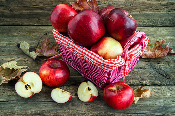 istock red apples in a basket on wooden background 472486438