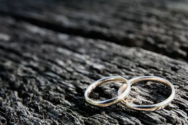 2 weddingrings on an old wooden bench