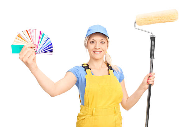 istock Woman holding a paint roller and a color guide 472489352