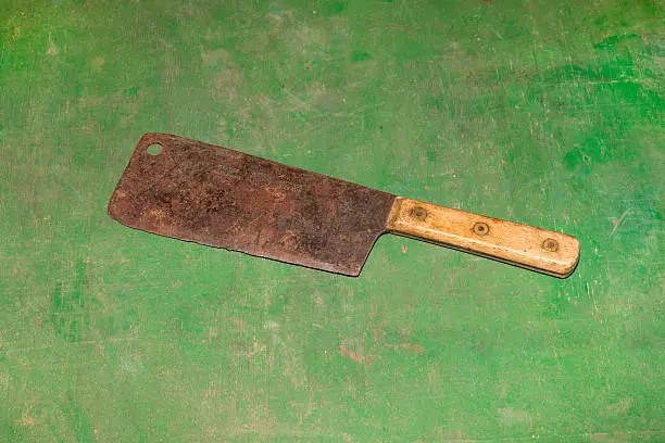 Rusted Vintage Meat Cleaver Isolated on Green Wooden Board in Studio.Shot with Canon 6D ISO 100