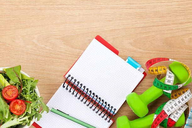 istock Healthy food, dumbells, tape measure and notepad for copy space 472492356