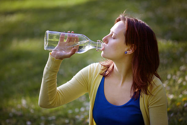 istock Young woman drinking water 472494528