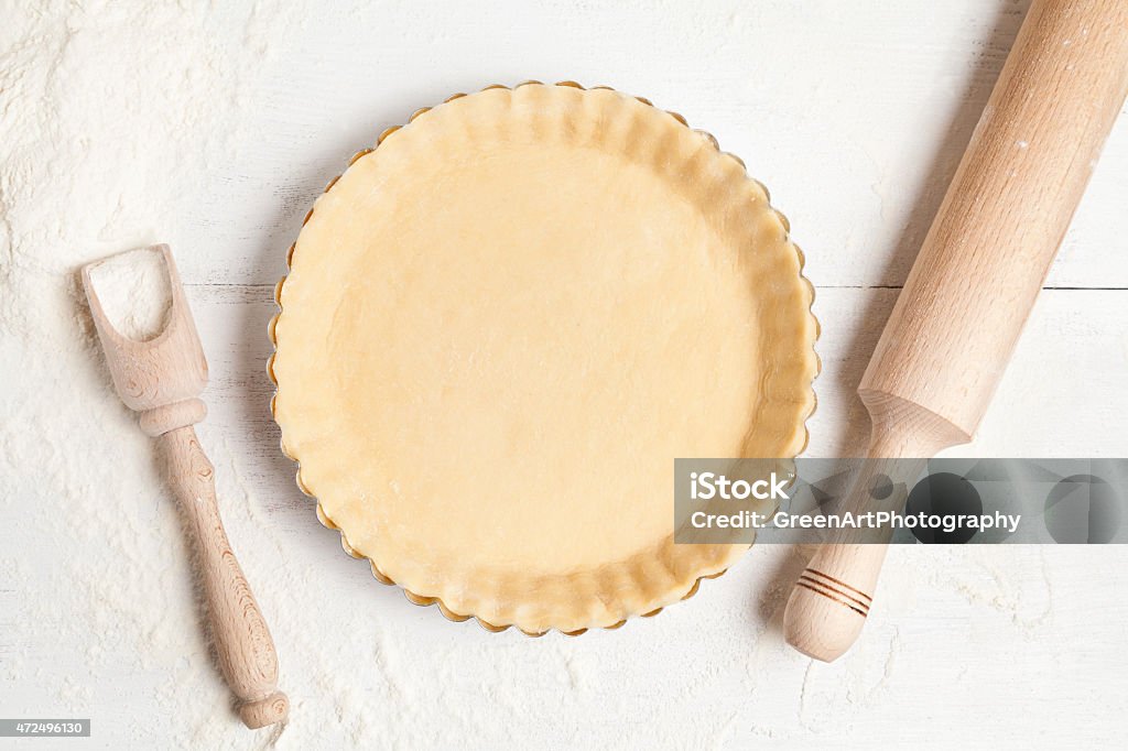 Tart pie preparation, dough with yeast and rolling pin on Homemade tart pie preparation, dough with yeast and rolling pin on white rustic kitchen table Savory Pie Stock Photo