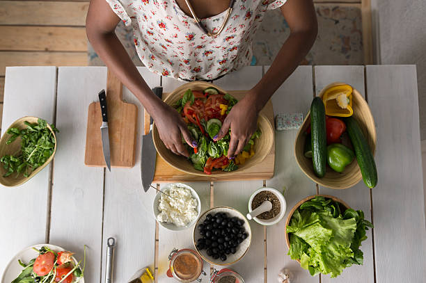 istock Young African Woman Cooking Salad 472499252