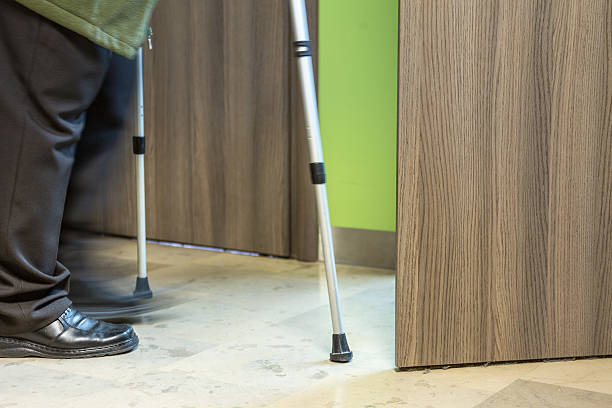 istock Elderly person using crutches entering opened door 472500006