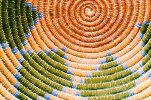 A close up photo of an inverted indian basket with a circular pattern and straw textures.