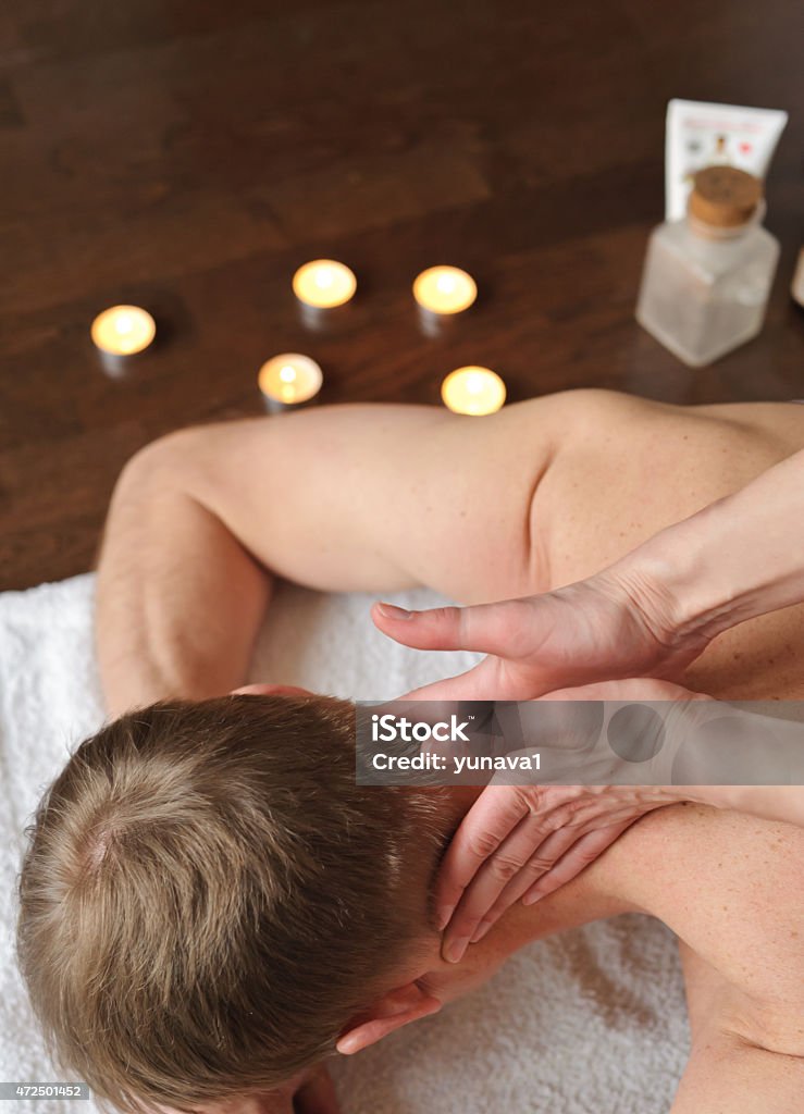 Neck Massage Woman doing massage to man. Her hands massaged her neck 2015 Stock Photo