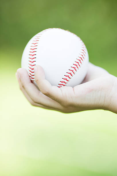 istock Close-up of child's hand holding baseball 472507140