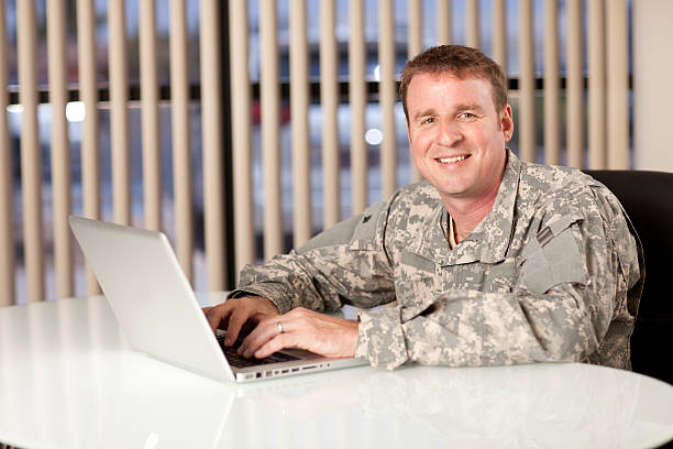 istock Portrait of a smiling soldier using laptop 472507250